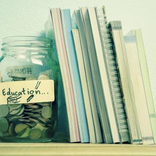 picture of a change jar labeled Education next to several schoolbooks on a shelf