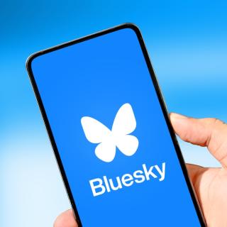 picture showing cell phone with bluesky logo on the screen