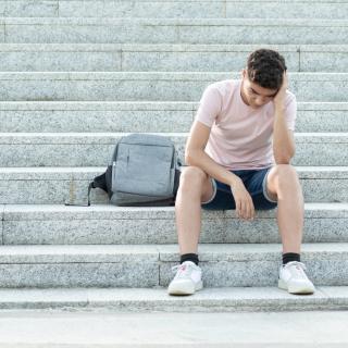 photo of sad latinx youth sitting on steps